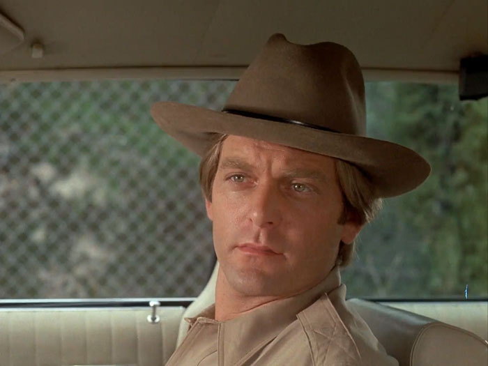 Close up of Brian Cutler as Deputy Dan Winston sitting in passenger seat of patrol car