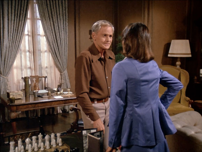 John Agar as Col. Duncan with Sabrina in his nice home, his writing desk in the background and table with chessboard and framed photos in the foreground.
