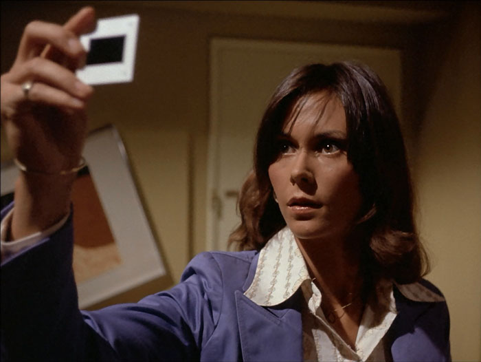 Sabrina looks at one of the slides in Wardlow's wrecked hotel room.