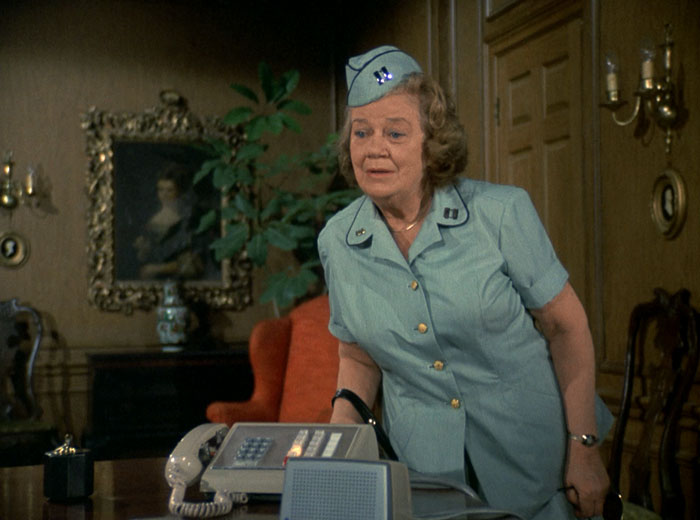 Cicely (Nora Marlowe) leans over Charlie's desk toward him